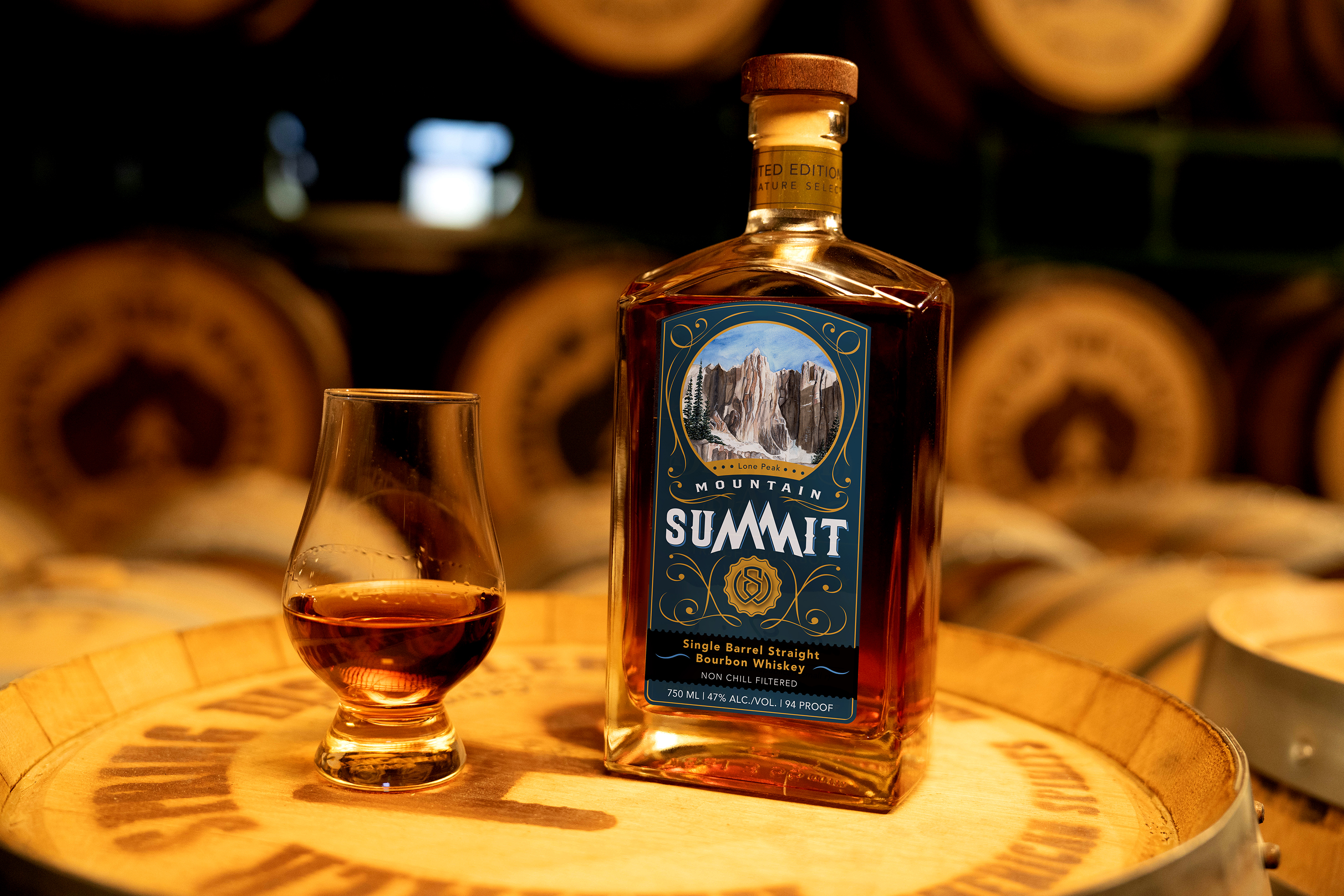 Mountain Summit: Single Barrel Bourbon Whiskey Bottle - Professionally photographed. Sitting atop an aging barrel.